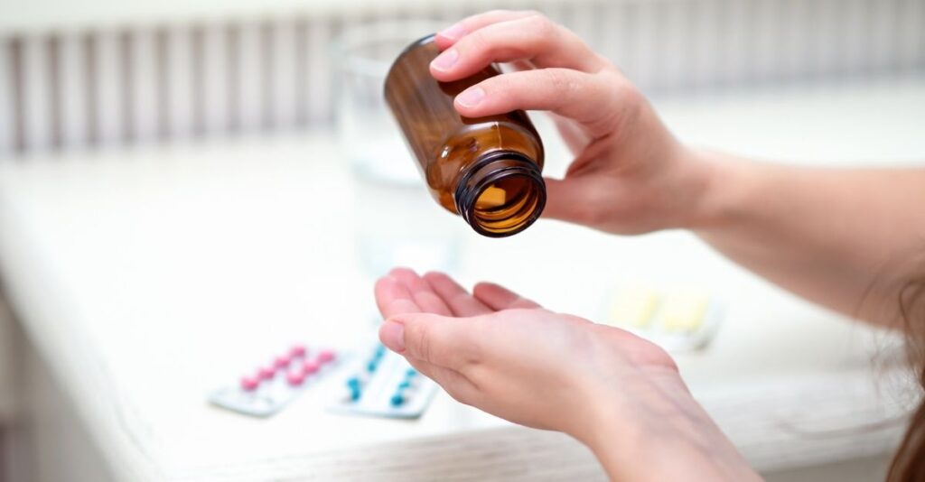 Mujer vaciando frasco de pastillas